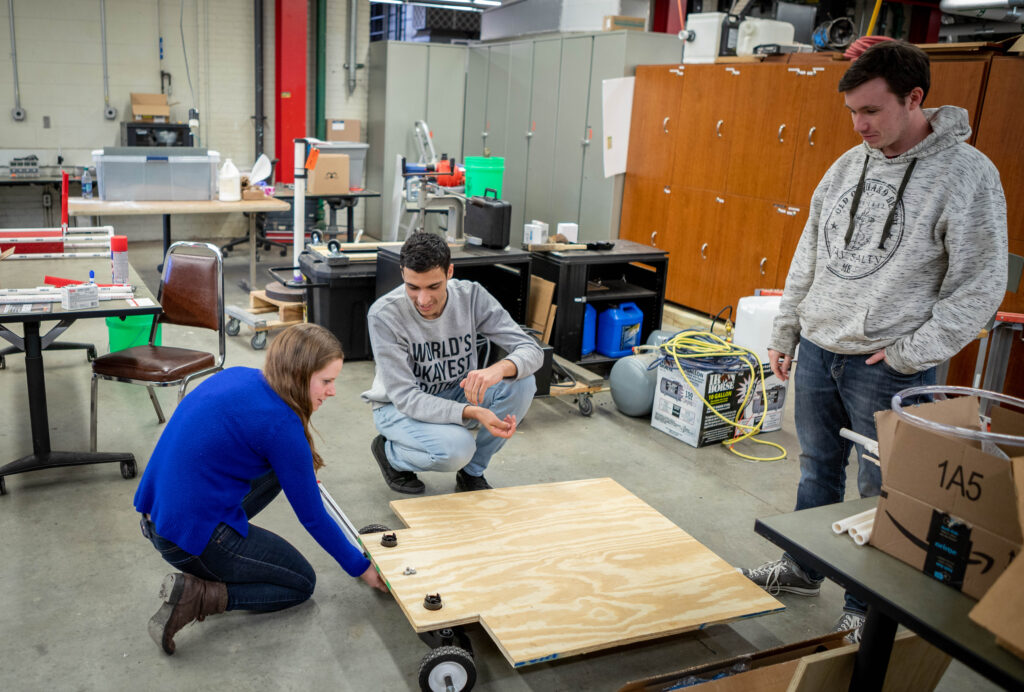 From Left to Right: Julia Oppenheimer, Marwan Ghellai and Cody Corey work on their platform in the machine shop in Castleman Building. (Eli Freund/UConn Photo)